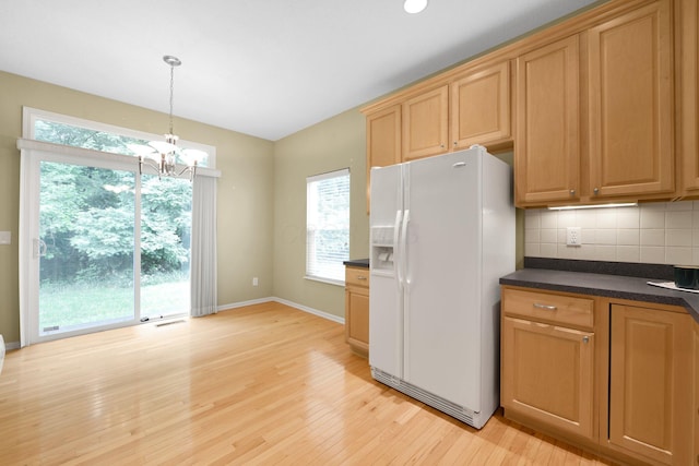 7931 Champaign Dr, Blacklick, OH 43004 - kitchen with white fridge with ice dispenser, dark countertops, healthy amount of natural light, light wood finished floors, and vaulted ceiling
