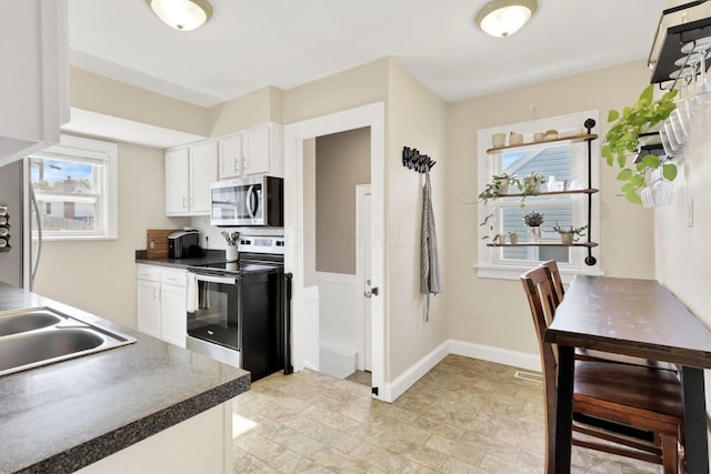 718 Harding Ave, Lancaster, OH 43130 - kitchen with stainless steel appliances, stone finish floors, healthy amount of natural light, and white cabinetry