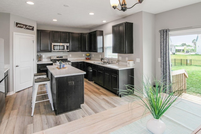 9146 Pennington Way, Blacklick, OH 43004 - kitchen featuring appliances with stainless steel finishes, light wood finished floors, recessed lighting, a center island, and light countertops