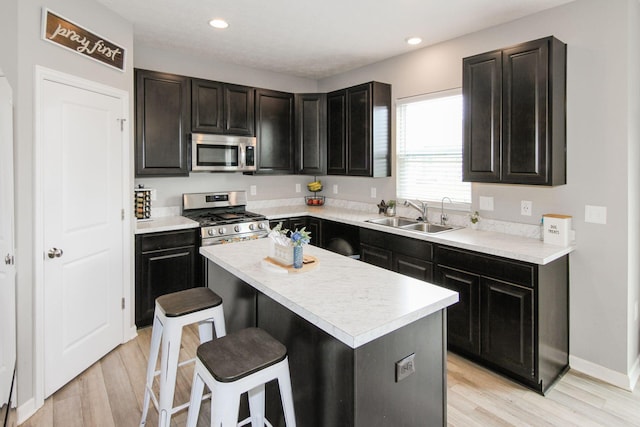 9146 Pennington Way, Blacklick, OH 43004 - kitchen featuring stainless steel appliances, a breakfast bar area, light wood-style floors, light countertops, and recessed lighting