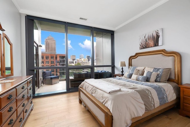 225 John H Mcconnell Blvd Unit 605, Columbus, OH 43215 - bedroom featuring a wall of windows, a view of skyline, light wood-style floors, and ornamental molding