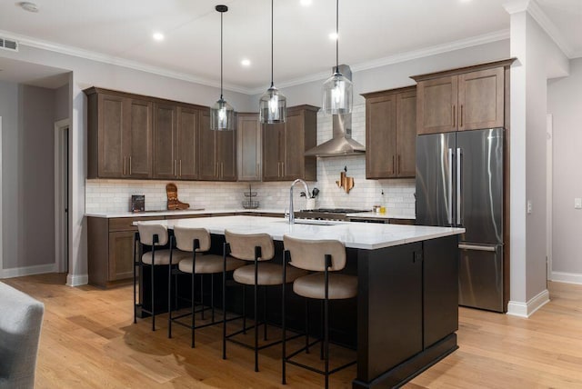 225 John H Mcconnell Blvd Unit 605, Columbus, OH 43215 - kitchen featuring freestanding refrigerator, light wood-style floors, an island with sink, backsplash, and crown molding
