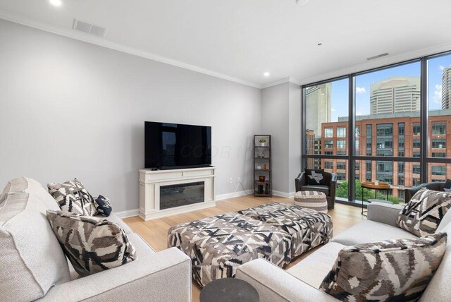 225 John H Mcconnell Blvd Unit 605, Columbus, OH 43215 - living area with expansive windows, plenty of natural light, light wood finished floors, crown molding, and a glass covered fireplace