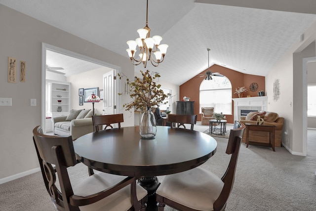 4188 Stoneworks Pl, New Albany, OH 43054 - dining space featuring a ceiling fan, light colored carpet, vaulted ceiling, a tiled fireplace, and a chandelier