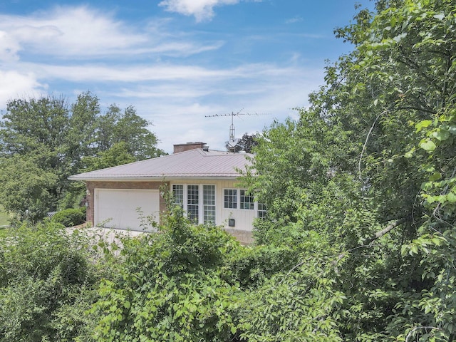 11620 Highland Park, Logan, OH 43138 - view of property exterior with an attached garage, brick siding, and a metal roof