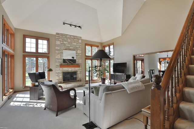 5720 Loch Maree Ct, Dublin, OH 43017 - living area with track lighting, high vaulted ceiling, a fireplace, stairway, and light colored carpet