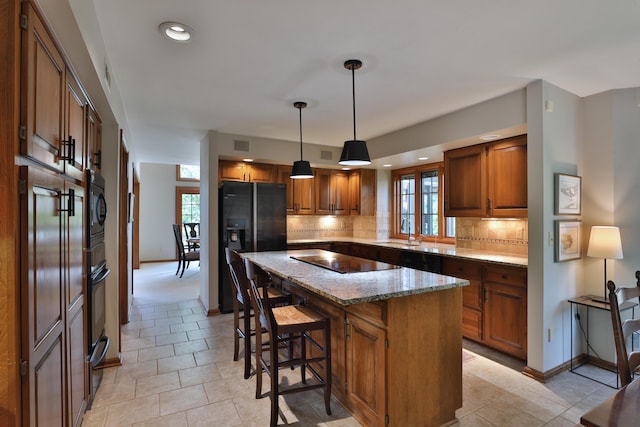 5720 Loch Maree Ct, Dublin, OH 43017 - kitchen with black appliances, brown cabinetry, a center island, tasteful backsplash, and recessed lighting