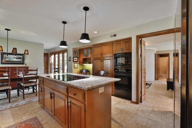 5720 Loch Maree Ct, Dublin, OH 43017 - kitchen featuring black appliances, brown cabinets, a center island, light stone counters, and hanging light fixtures