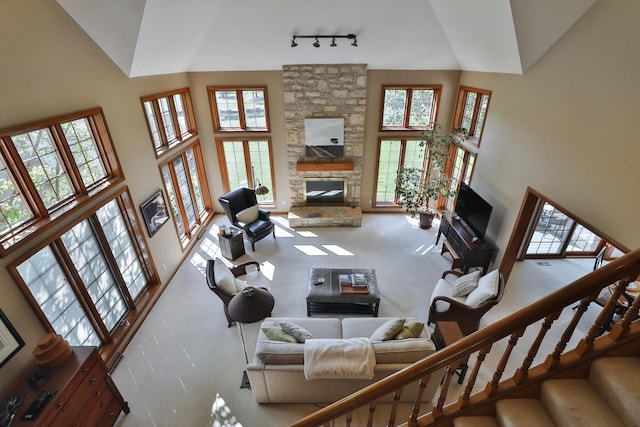 5720 Loch Maree Ct, Dublin, OH 43017 - carpeted living room featuring high vaulted ceiling, a stone fireplace, stairs, and rail lighting