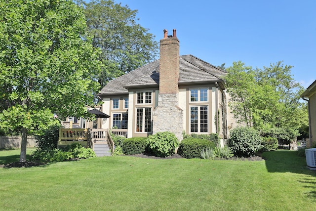 5720 Loch Maree Ct, Dublin, OH 43017 - back of house featuring a yard, stucco siding, a wooden deck, a chimney, and stone siding
