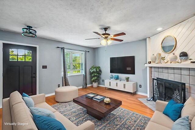 4905 Mckenna Ct, Columbus, OH 43221 - living area featuring a ceiling fan, wood finished floors, a fireplace, and a textured ceiling