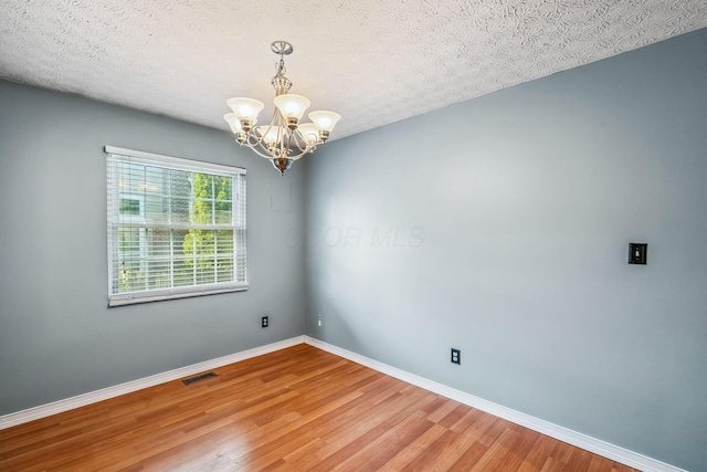 4905 Mckenna Ct, Columbus, OH 43221 - empty room with a chandelier, wood finished floors, and a textured ceiling