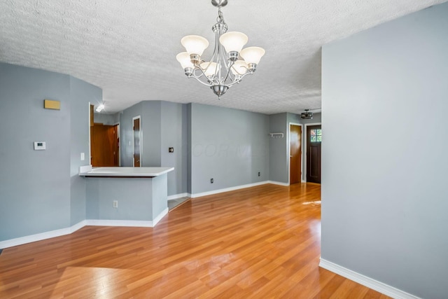 4905 Mckenna Ct, Columbus, OH 43221 - empty room with a chandelier, a textured ceiling, and light wood-style floors
