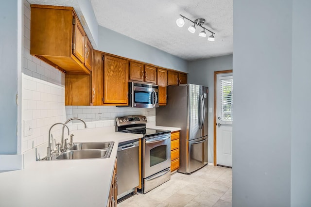 4905 Mckenna Ct, Columbus, OH 43221 - kitchen with appliances with stainless steel finishes, a textured ceiling, tasteful backsplash, brown cabinetry, and light countertops