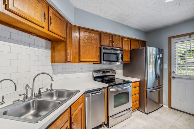 4905 Mckenna Ct, Columbus, OH 43221 - kitchen featuring stainless steel appliances, brown cabinets, backsplash, light countertops, and a textured ceiling