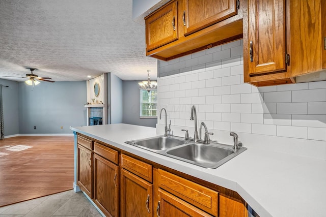 4905 Mckenna Ct, Columbus, OH 43221 - kitchen featuring backsplash, brown cabinets, light countertops, a ceiling fan, and a textured ceiling