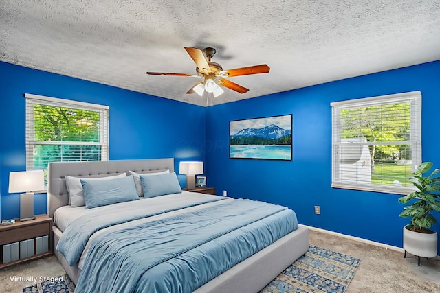 4905 Mckenna Ct, Columbus, OH 43221 - carpeted bedroom with multiple windows, a textured ceiling, and ceiling fan