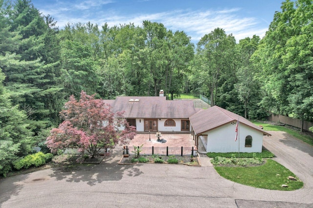 71 Denison Dr, Granville, OH 43023 - view of front facade with asphalt driveway, a chimney, and a wooded view