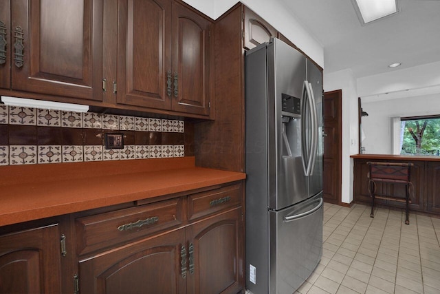 71 Denison Dr, Granville, OH 43023 - kitchen with stainless steel refrigerator with ice dispenser, light tile patterned floors, tasteful backsplash, dark brown cabinets, and light countertops