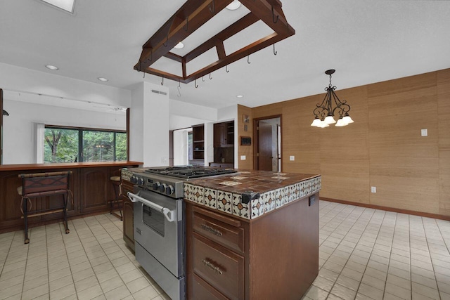 71 Denison Dr, Granville, OH 43023 - kitchen with stainless steel stove, dark countertops, light tile patterned floors, a chandelier, and recessed lighting