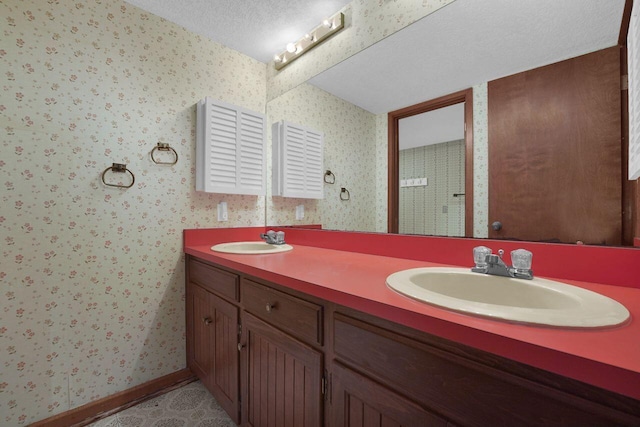71 Denison Dr, Granville, OH 43023 - bathroom with double vanity, wallpapered walls, and a textured ceiling