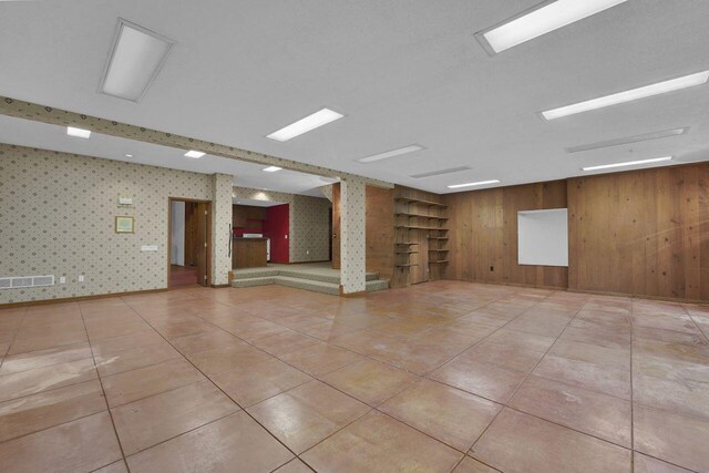 71 Denison Dr, Granville, OH 43023 - unfurnished room with light tile patterned floors, wooden walls, and wallpapered walls
