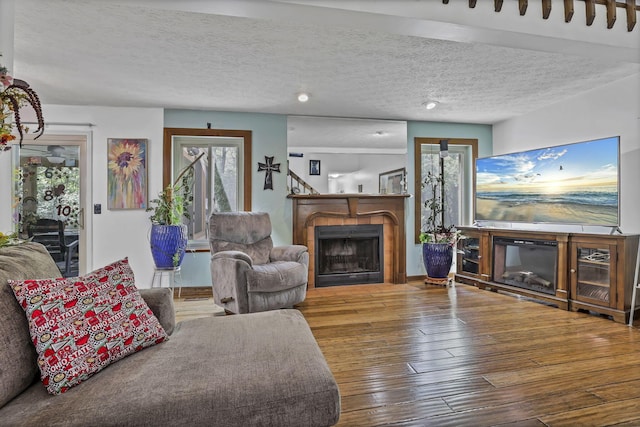 389 Fenway Rd Unit B, Columbus, OH 43214 - living area featuring a tile fireplace, hardwood / wood-style floors, and a textured ceiling