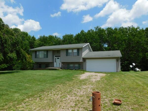 7670 Zwickle Rd, Logan, OH 43138 - split foyer home featuring dirt driveway, a front lawn, and an attached garage
