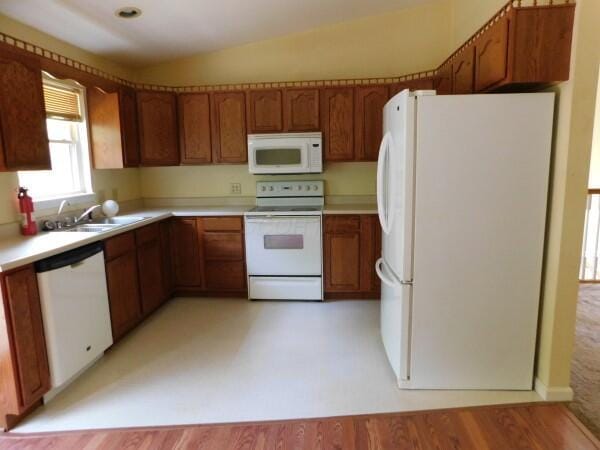 7670 Zwickle Rd, Logan, OH 43138 - kitchen with white appliances, brown cabinets, light countertops, and light wood-style floors