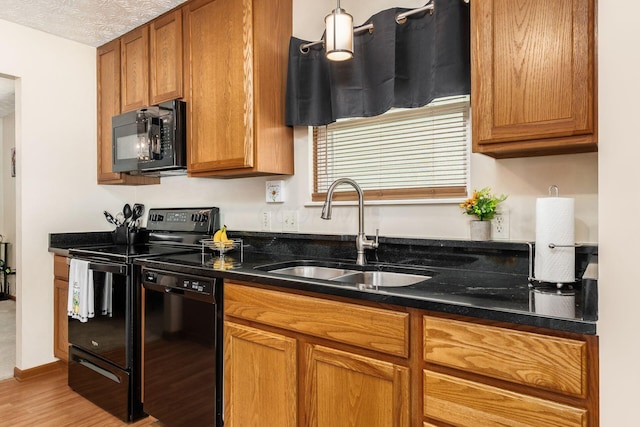 281 Inah Ave, Columbus, OH 43228 - kitchen with black appliances, light wood finished floors, and brown cabinetry