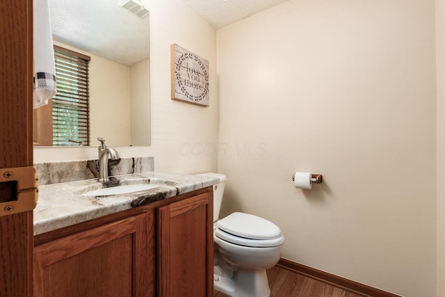 281 Inah Ave, Columbus, OH 43228 - half bath with vanity, wood finished floors, and a textured ceiling