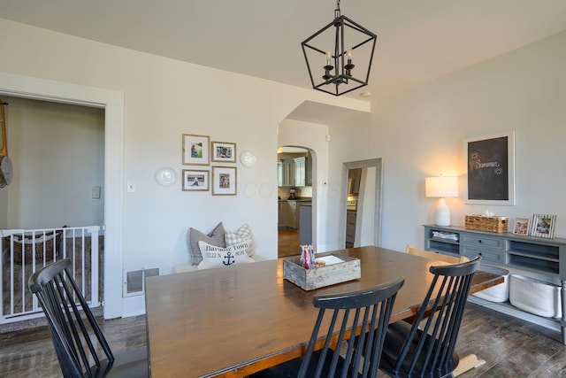 162 Watt St, Circleville, OH 43113 - dining area featuring arched walkways, dark wood finished floors, and a chandelier