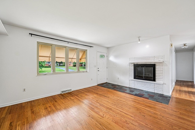 902 Brentford Dr, Columbus, OH 43220 - unfurnished living room with wood-type flooring and a brick fireplace