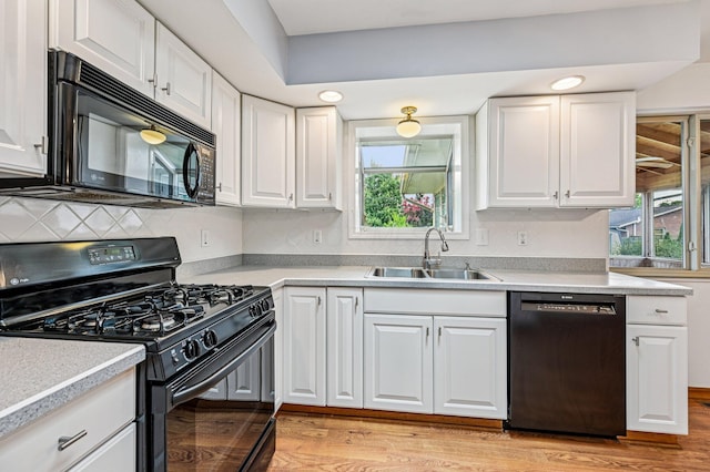 902 Brentford Dr, Columbus, OH 43220 - kitchen featuring black appliances, light wood finished floors, and white cabinetry