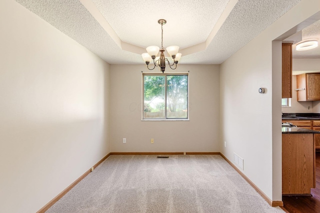 7345 Oakmeadows Dr, Columbus, OH 43085 - unfurnished dining area with a textured ceiling, a chandelier, carpet flooring, and a raised ceiling