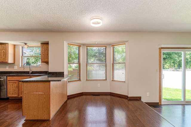 7345 Oakmeadows Dr, Columbus, OH 43085 - kitchen featuring a peninsula, dark wood finished floors, dark countertops, plenty of natural light, and a textured ceiling