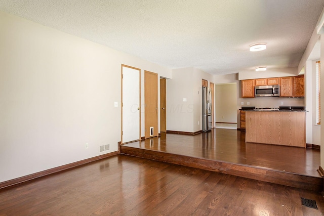 7345 Oakmeadows Dr, Columbus, OH 43085 - unfurnished living room featuring dark wood finished floors and a textured ceiling
