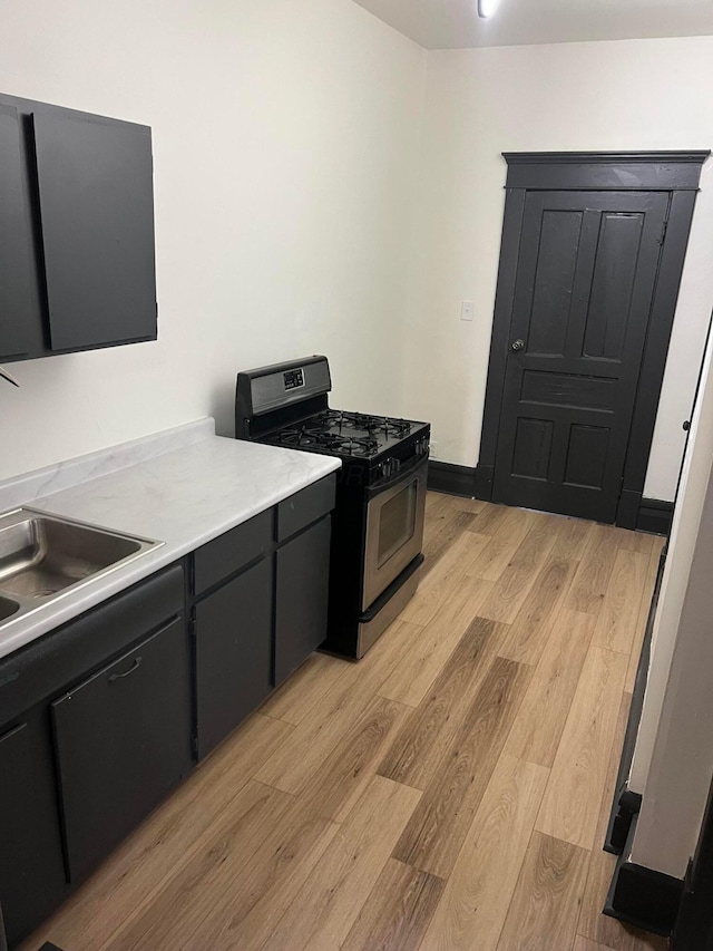 51 E N St, Newark, OH 43055 - kitchen featuring stainless steel range with gas cooktop, light wood-type flooring, light countertops, and dark cabinetry