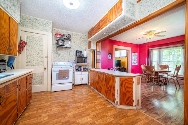 559 Pearl St, Marion, OH 43302 - kitchen featuring white electric range, light wood-style flooring, a textured ceiling, brown cabinets, and a peninsula