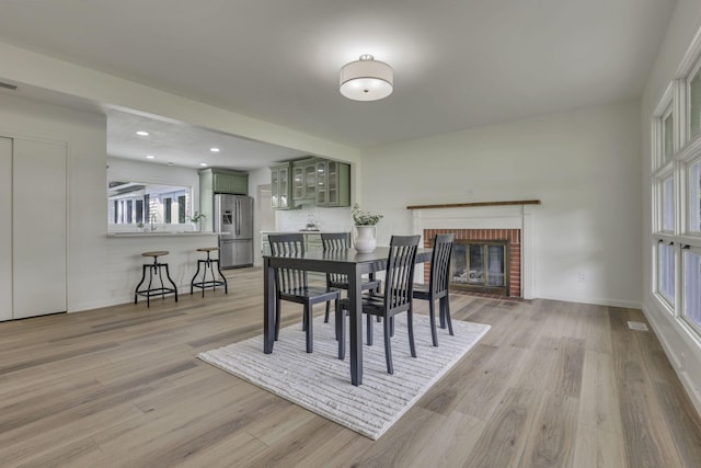 1080 Coonpath Rd NW, Lancaster, OH 43130 - dining space with light wood finished floors, a brick fireplace, and recessed lighting