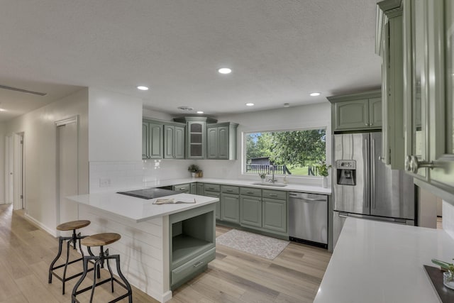 1080 Coonpath Rd NW, Lancaster, OH 43130 - kitchen featuring appliances with stainless steel finishes, green cabinetry, a peninsula, light wood finished floors, and recessed lighting