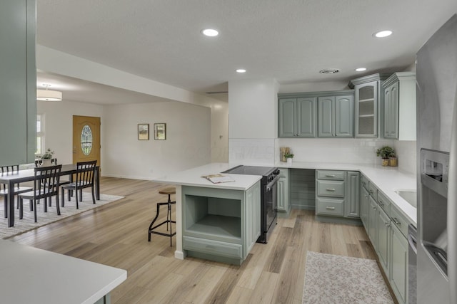 1080 Coonpath Rd NW, Lancaster, OH 43130 - kitchen featuring electric stove, a peninsula, light countertops, backsplash, and light wood-style flooring