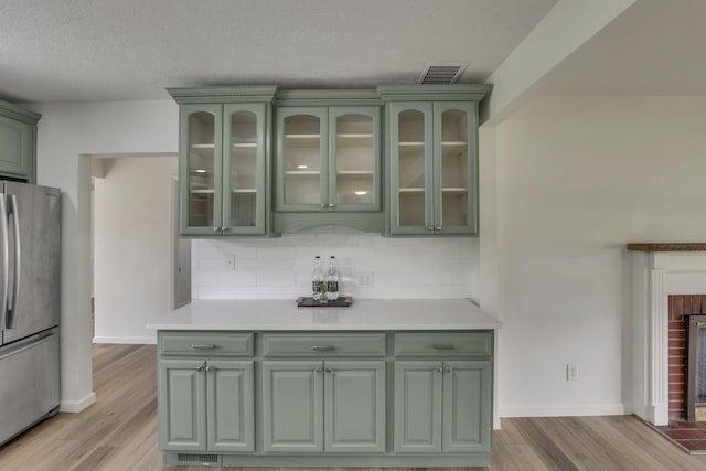 1080 Coonpath Rd NW, Lancaster, OH 43130 - bar featuring freestanding refrigerator, light wood-style flooring, decorative backsplash, a textured ceiling, and a fireplace