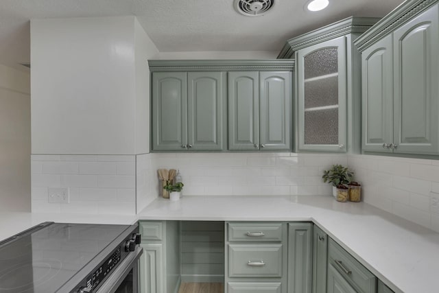 1080 Coonpath Rd NW, Lancaster, OH 43130 - kitchen with stainless steel range with electric cooktop, green cabinets, backsplash, and light countertops