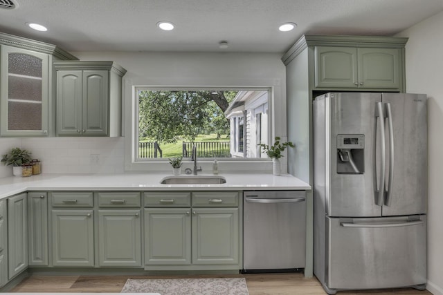 1080 Coonpath Rd NW, Lancaster, OH 43130 - kitchen with stainless steel appliances, green cabinetry, light countertops, light wood-style flooring, and tasteful backsplash