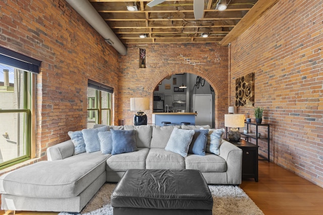 51 W Blenkner St Unit 306, Columbus, OH 43215 - living room with brick wall, a towering ceiling, wood finished floors, arched walkways, and beam ceiling