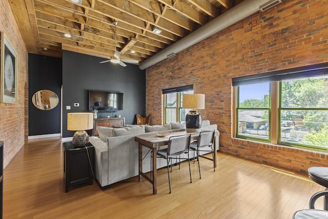 51 W Blenkner St Unit 306, Columbus, OH 43215 - living area featuring brick wall, light wood finished floors, a ceiling fan, healthy amount of natural light, and a high ceiling