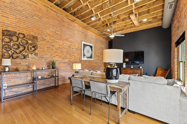 51 W Blenkner St Unit 306, Columbus, OH 43215 - living area with high vaulted ceiling, a ceiling fan, wood finished floors, brick wall, and a wooden ceiling with exposed beams