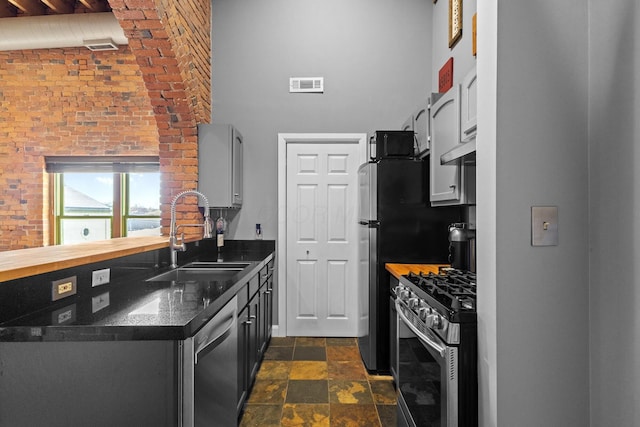 51 W Blenkner St Unit 306, Columbus, OH 43215 - kitchen featuring appliances with stainless steel finishes, a towering ceiling, dark countertops, and dark stone finish flooring
