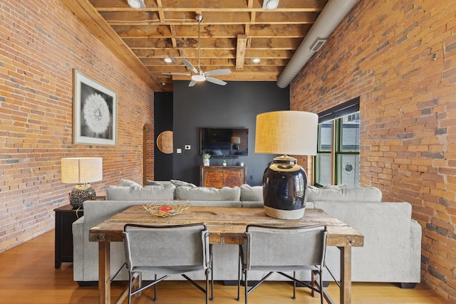51 W Blenkner St Unit 306, Columbus, OH 43215 - living area featuring brick wall, wood finished floors, a ceiling fan, and a wooden ceiling with exposed beams